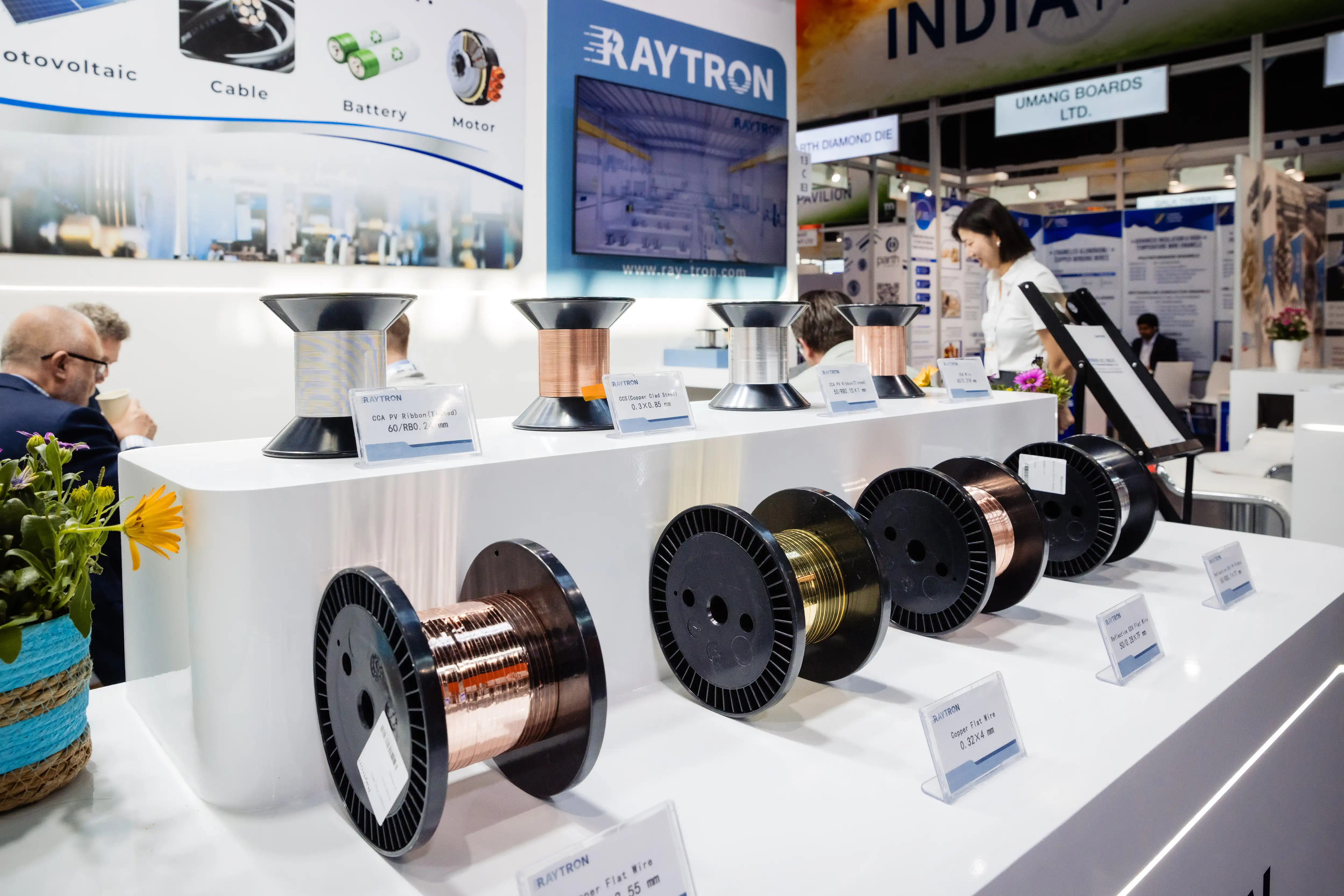 访客仔细观察RAYTRON双金属横截面样品和技术展示